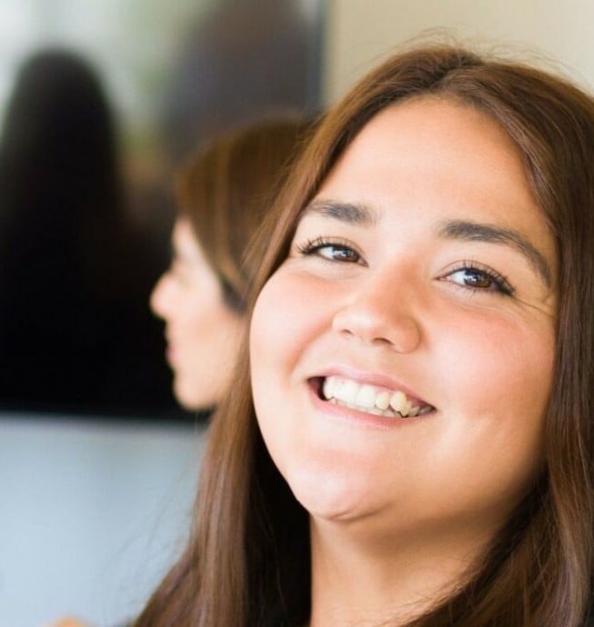 Lachende vrouw met een vrouw op de achtergrond bezig met het werken bij een christelijke organisatie.