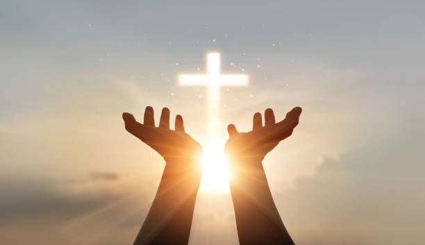 Een handenpalm omhoog biddend en aanbiddend tot het kruis, eucharistische therapie zegent God die helpt, hoop en geloof, christelijk religieconcept tegen een achtergrond van zonsondergang.