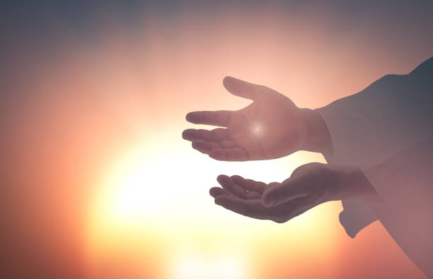 Concept van Hemelvaartsdag: Jezus Christus toont zijn handen met littekens aan Thomas tegen een vage achtergrond van de zonsondergang.