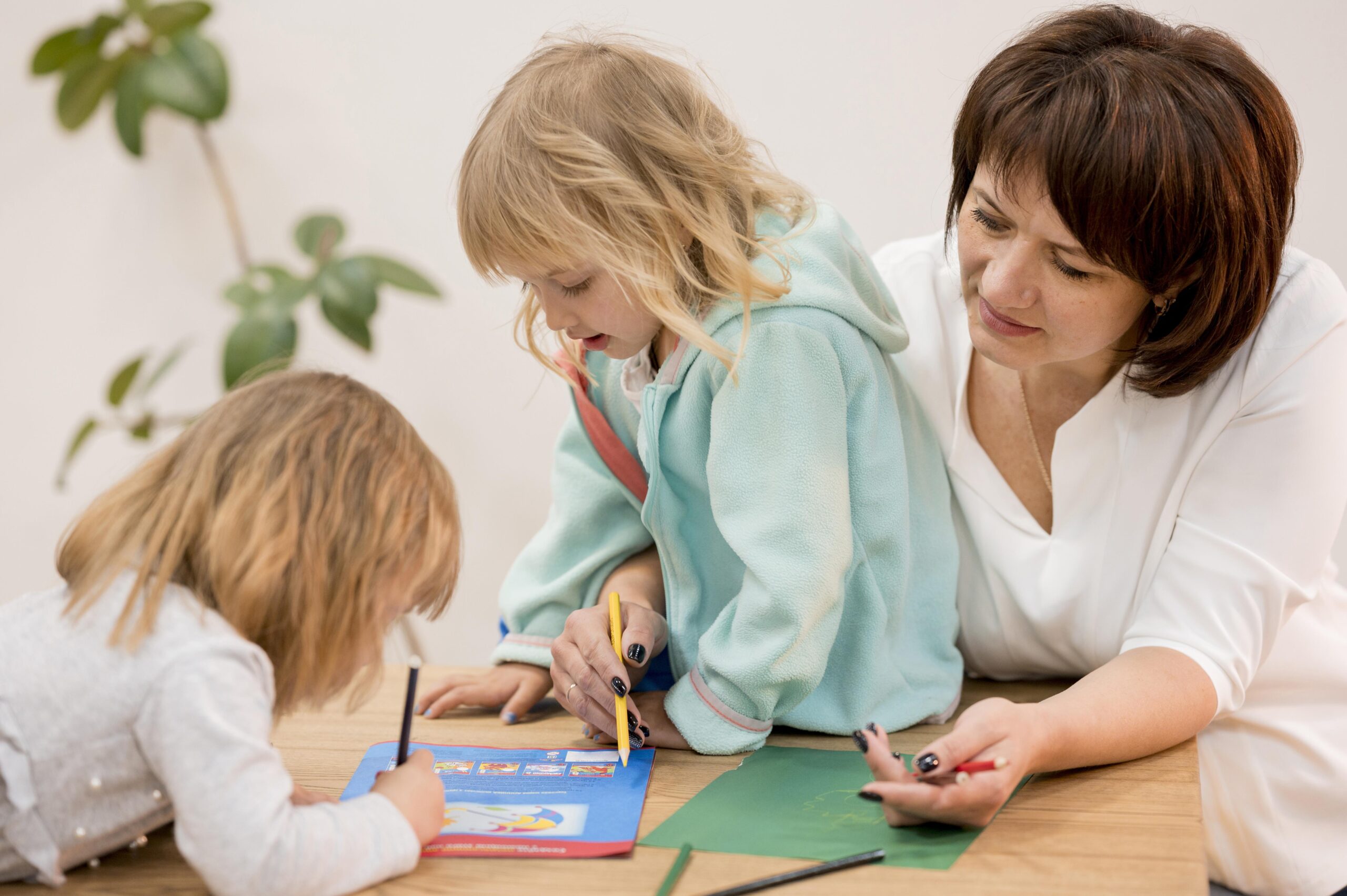 OUdere vrouw die kinderen helpt bij tekenen